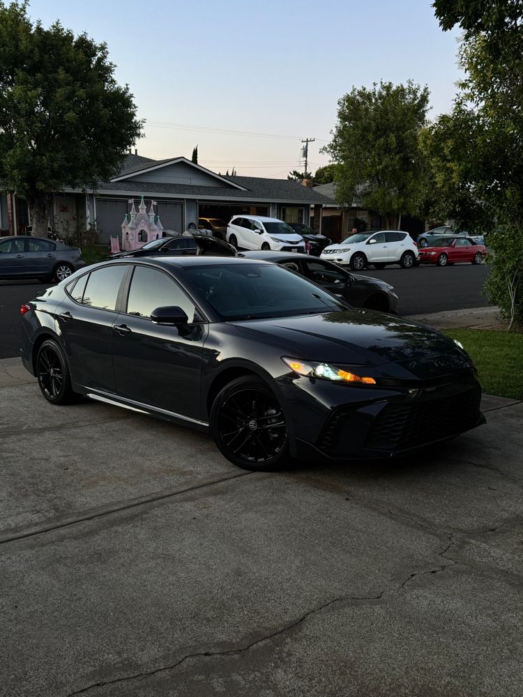 Dark Toyota sedan with a glossy finish parked on a driveway